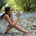 Ein Buch lesen am Fluss