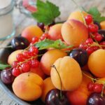 Obstteller mit Kirschen, Pfirsich und Johannisbeeren